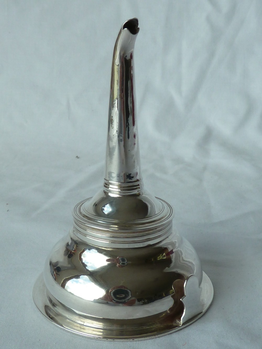 A Georgian sterling silver three-piece wine funnel shown disassembled into a pierced ring, curved spout base, and silver bowl. View VI