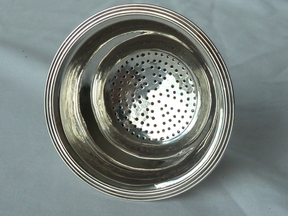 A Georgian sterling silver three-piece wine funnel shown disassembled into a pierced ring, curved spout base, and silver bowl. View VII
