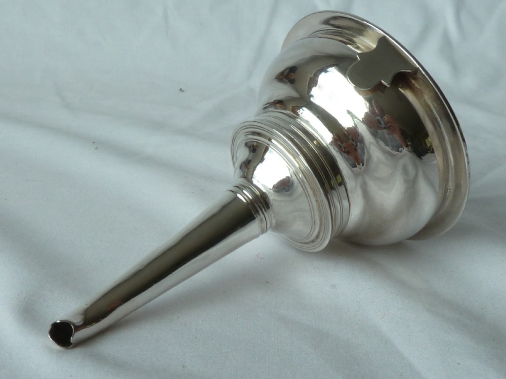 A Georgian sterling silver three-piece wine funnel shown disassembled into a pierced ring, curved spout base, and silver bowl. View VIII