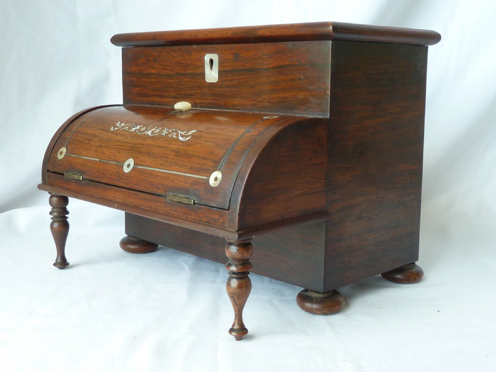 A Victorian novelty stationery box constructed from dark rosewood in the shape of an upright piano, adorned with mother-of-pearl floral inlay and turned front legs. View II