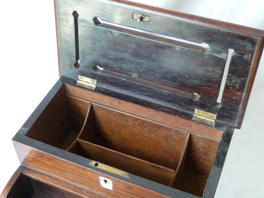 A Victorian novelty stationery box constructed from dark rosewood in the shape of an upright piano, adorned with mother-of-pearl floral inlay and turned front legs. View VI