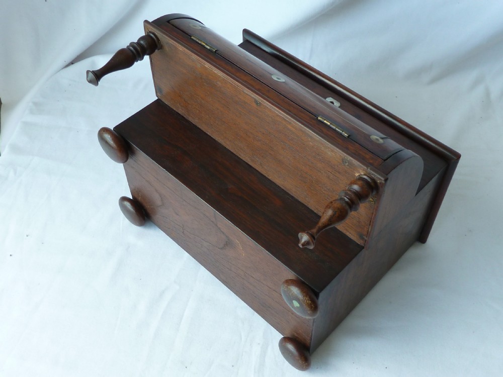 A Victorian novelty stationery box constructed from dark rosewood in the shape of an upright piano, adorned with mother-of-pearl floral inlay and turned front legs. View VII