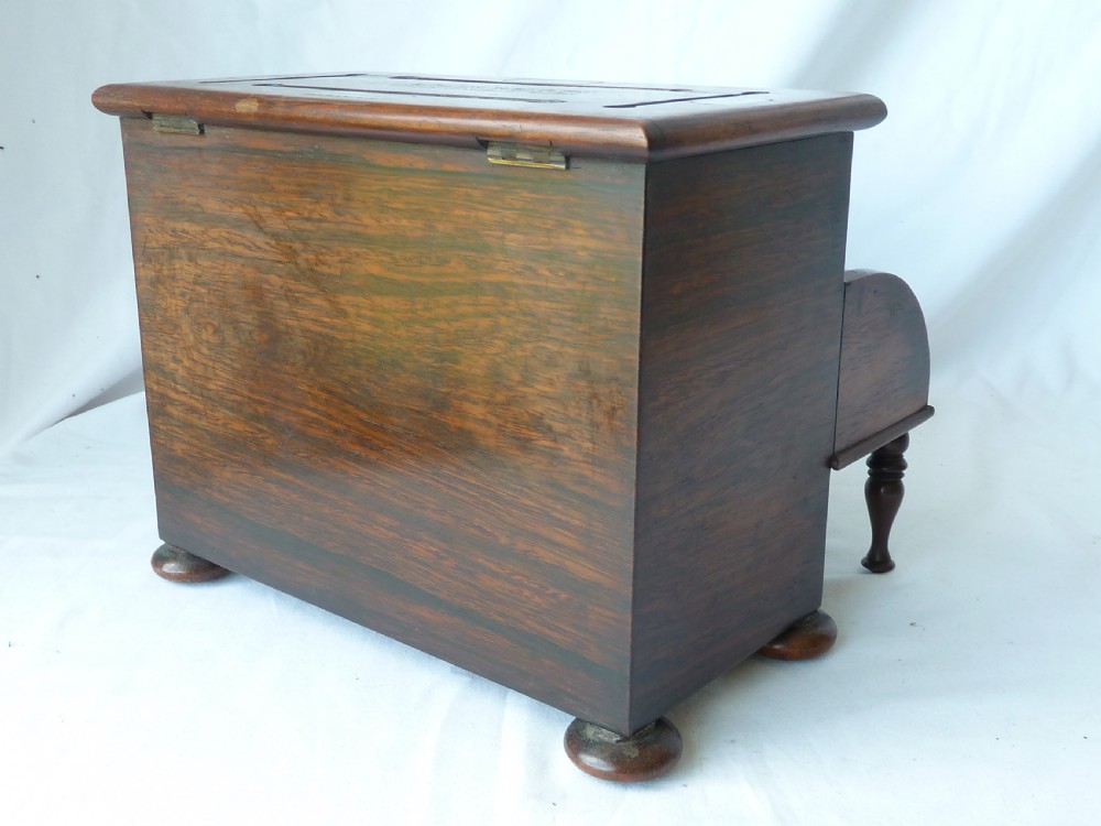 A Victorian novelty stationery box constructed from dark rosewood in the shape of an upright piano, adorned with mother-of-pearl floral inlay and turned front legs. View VIII