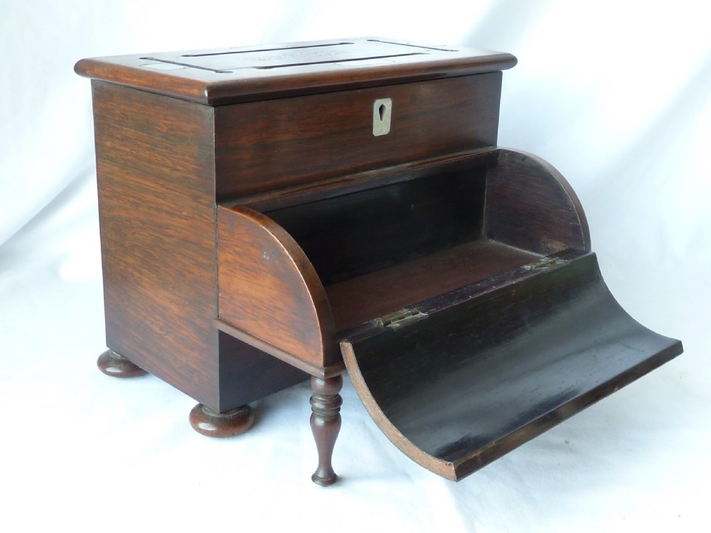 A Victorian novelty stationery box constructed from dark rosewood in the shape of an upright piano, adorned with mother-of-pearl floral inlay and turned front legs. View IX