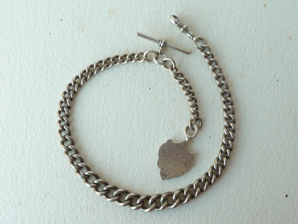 A solid sterling silver Victorian Albert pocket watch chain featuring curb links, a T-bar, swivel clasp, and a heraldic enamelled shield fob. View II