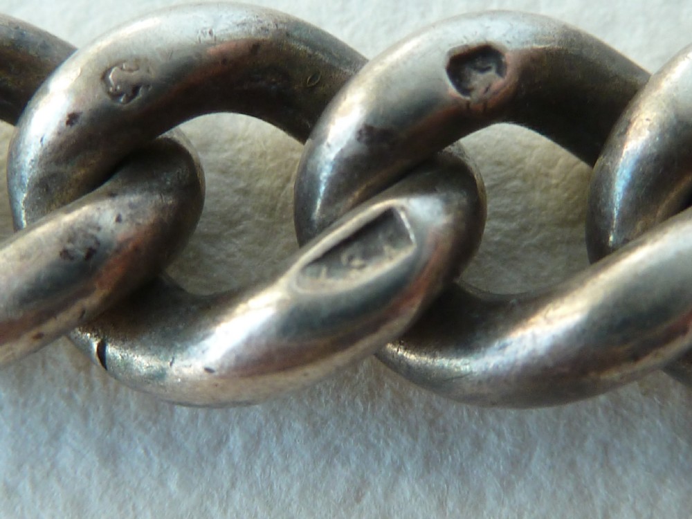 A solid sterling silver Victorian Albert pocket watch chain featuring curb links, a T-bar, swivel clasp, and a heraldic enamelled shield fob. View V