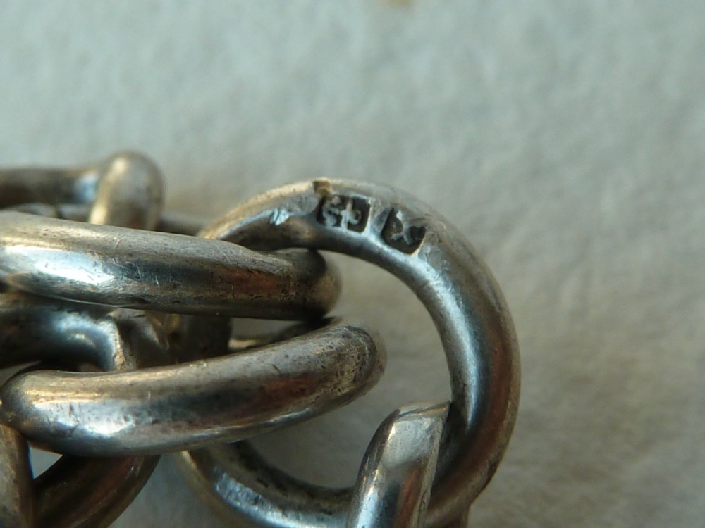A solid sterling silver Victorian Albert pocket watch chain featuring curb links, a T-bar, swivel clasp, and a heraldic enamelled shield fob. View VI
