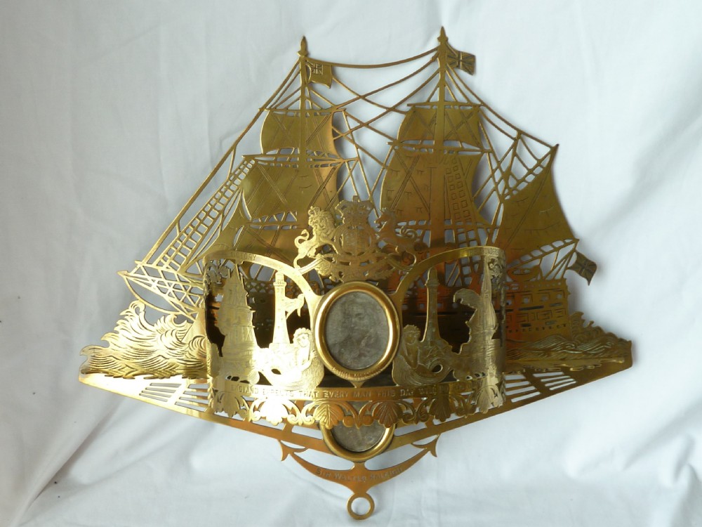 An ornate Victorian pressed brass wall pocket featuring a detailed nautical scene with sailing ships, crests, and portrait medallions.