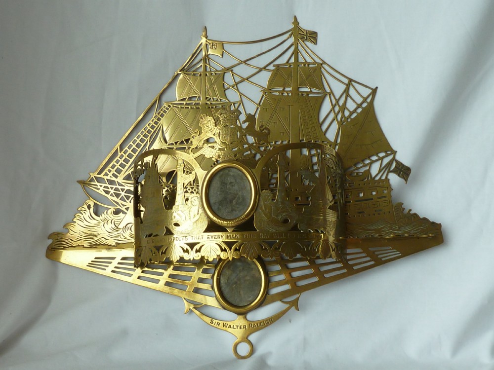 An ornate Victorian pressed brass wall pocket featuring a detailed nautical scene with sailing ships, crests, and portrait medallions. View II