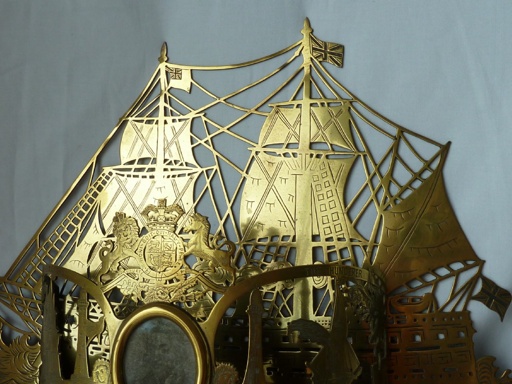An ornate Victorian pressed brass wall pocket featuring a detailed nautical scene with sailing ships, crests, and portrait medallions. View III