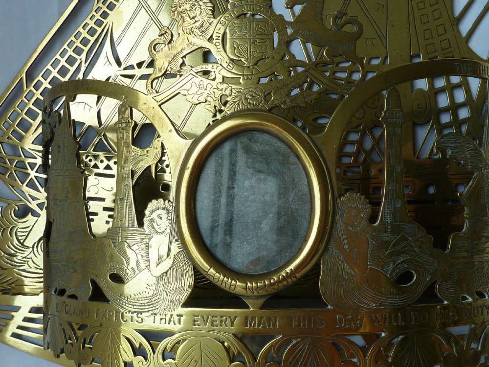 An ornate Victorian pressed brass wall pocket featuring a detailed nautical scene with sailing ships, crests, and portrait medallions. View IV