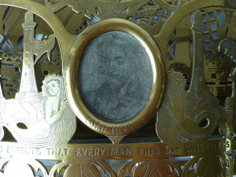 An ornate Victorian pressed brass wall pocket featuring a detailed nautical scene with sailing ships, crests, and portrait medallions. View V