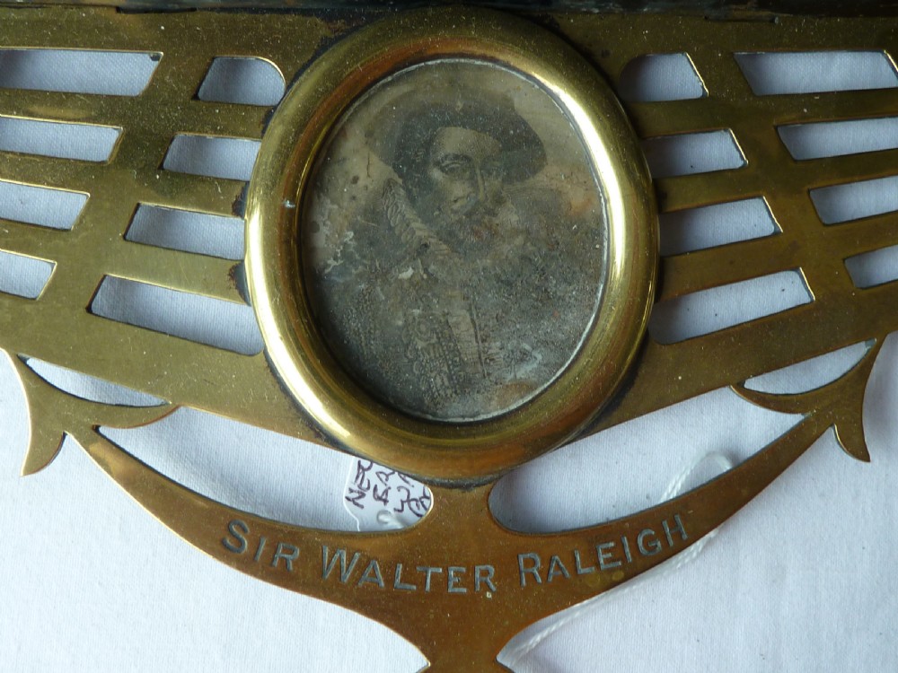 An ornate Victorian pressed brass wall pocket featuring a detailed nautical scene with sailing ships, crests, and portrait medallions. View VI