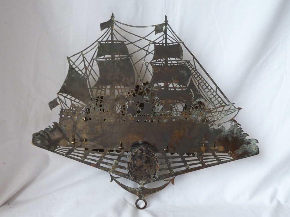 An ornate Victorian pressed brass wall pocket featuring a detailed nautical scene with sailing ships, crests, and portrait medallions. View IX