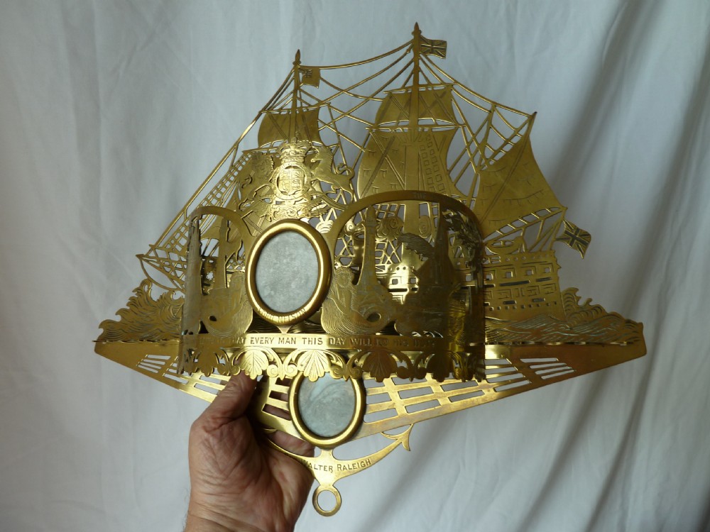 An ornate Victorian pressed brass wall pocket featuring a detailed nautical scene with sailing ships, crests, and portrait medallions. View X
