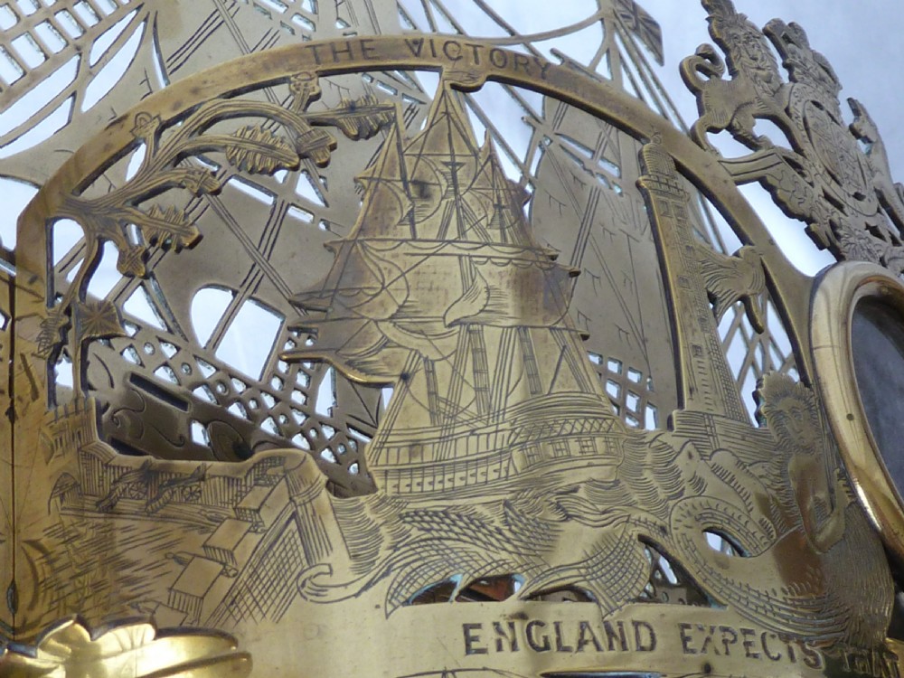 An ornate Victorian pressed brass wall pocket featuring a detailed nautical scene with sailing ships, crests, and portrait medallions. View XII