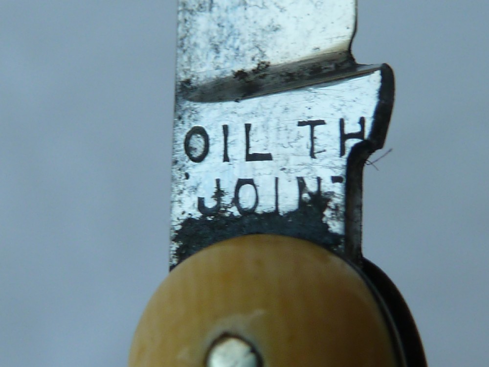A cream ivorine folding pocket knife moulded in the shape of a female nude figure with two partially opened steel blades. View III