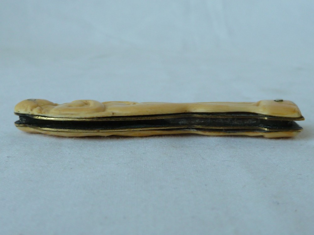 A cream ivorine folding pocket knife moulded in the shape of a female nude figure with two partially opened steel blades. View VIII