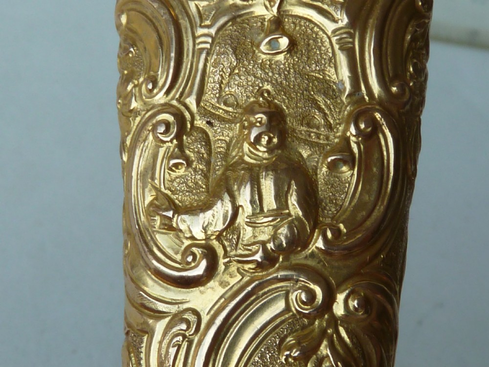 An 18th-century style tapered gold-coloured metal sheath embossed with intricate scrollwork, containing cut steel embroidery scissors. View III
