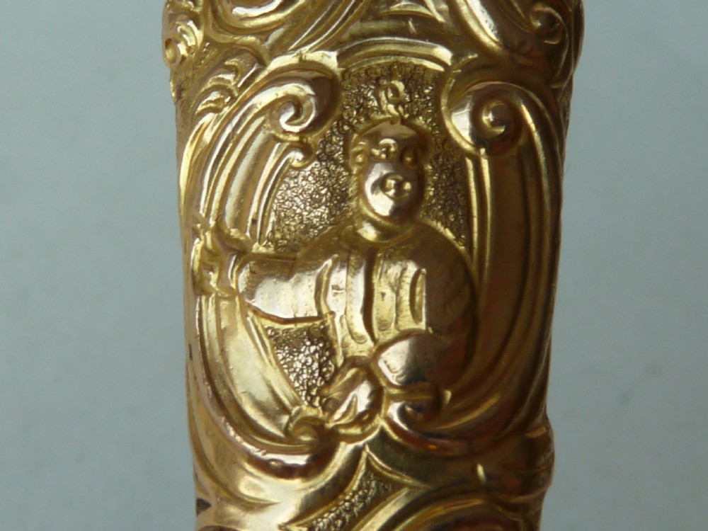 An 18th-century style tapered gold-coloured metal sheath embossed with intricate scrollwork, containing cut steel embroidery scissors. View IV
