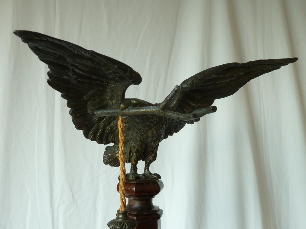 A tall mahogany column table lamp featuring a cast bronze eagle perched at the top above a stepped square plinth base. View II