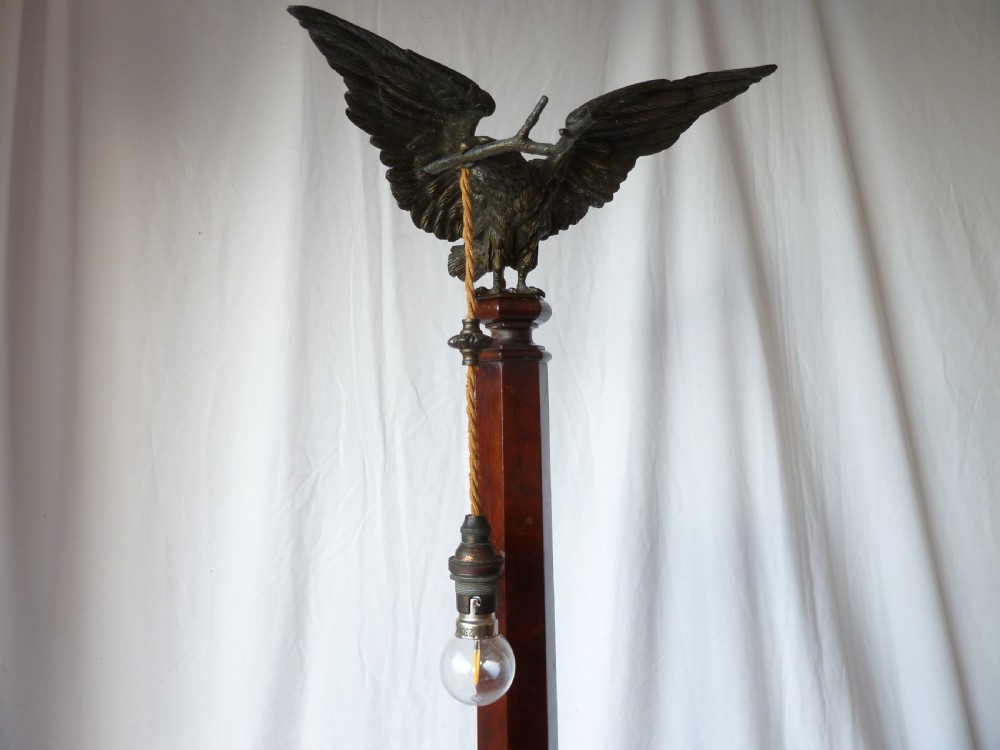 A tall mahogany column table lamp featuring a cast bronze eagle perched at the top above a stepped square plinth base. View V