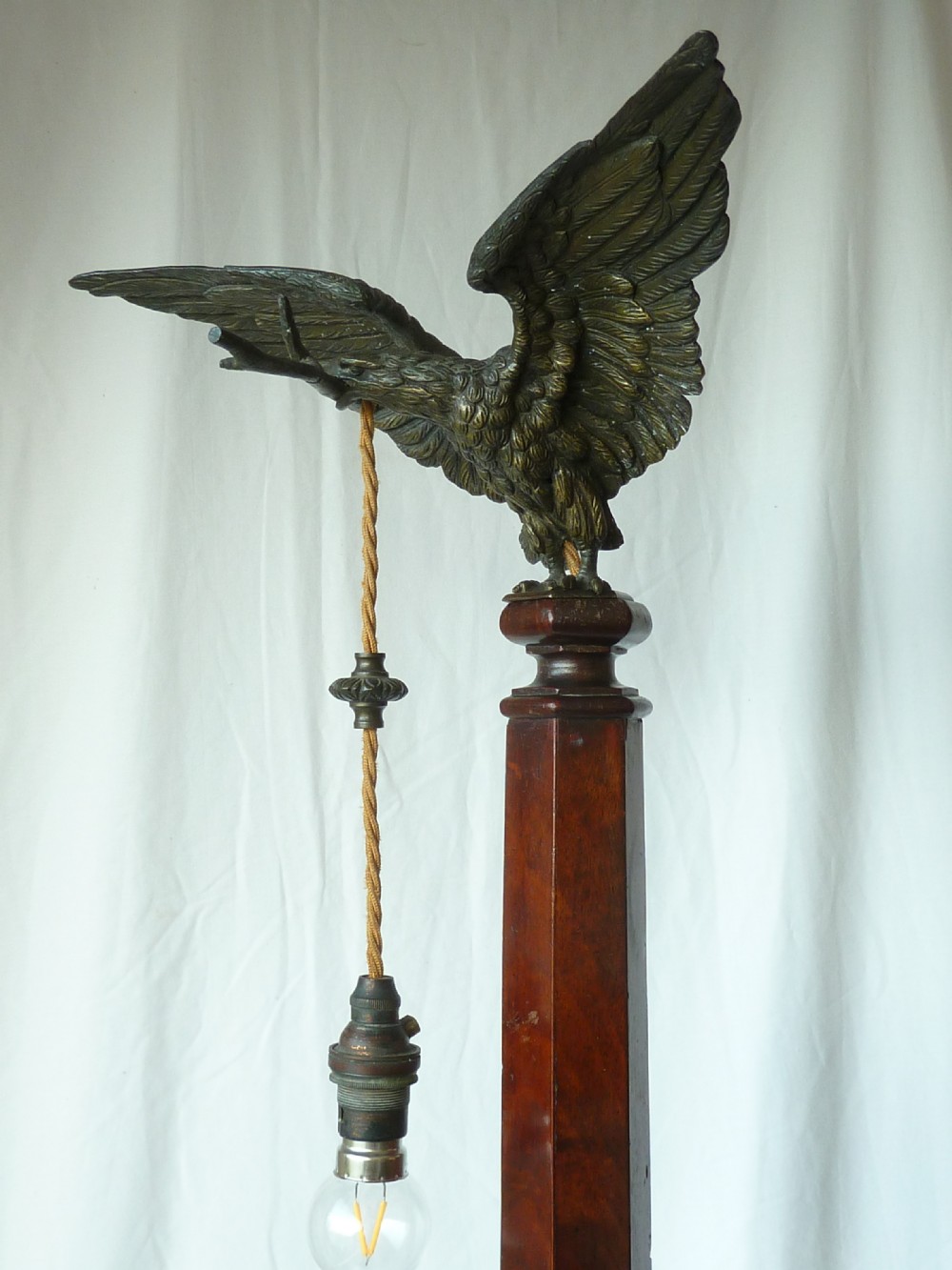A tall mahogany column table lamp featuring a cast bronze eagle perched at the top above a stepped square plinth base. View VI