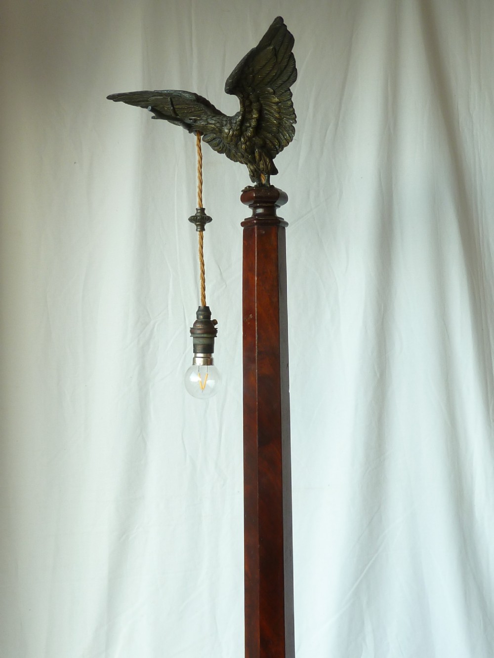 A tall mahogany column table lamp featuring a cast bronze eagle perched at the top above a stepped square plinth base. View VIII