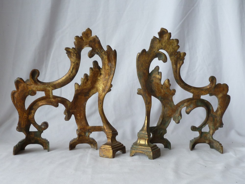 A pair of cast gilt brass French Rococo style fire dogs with elaborate acanthus leaf C-scroll design on small pedestal feet. View III
