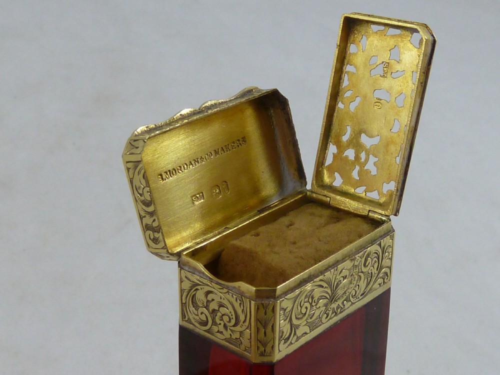 A faceted rectangular ruby red glass scent bottle featuring intricate scroll-engraved silver-gilt mounts at the cap and base. View VI
