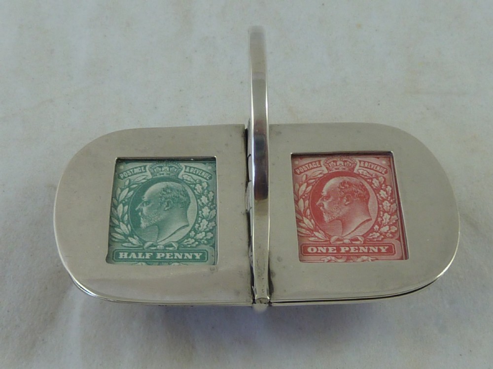 An Edwardian sterling silver double stamp case shaped like a garden trug with an overhead handle and two glazed stamp display compartments. View III