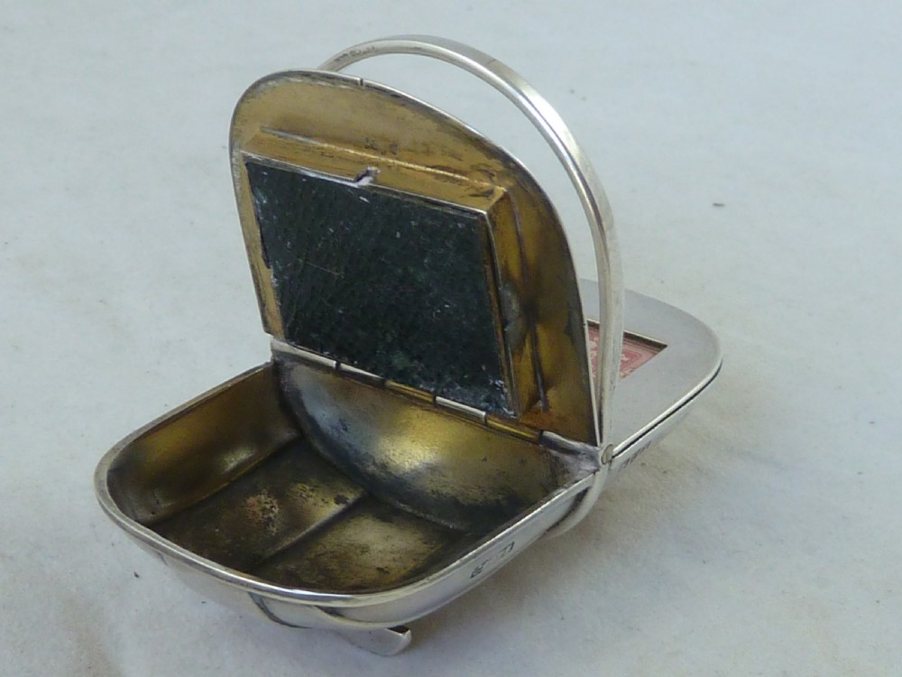 An Edwardian sterling silver double stamp case shaped like a garden trug with an overhead handle and two glazed stamp display compartments. View IV