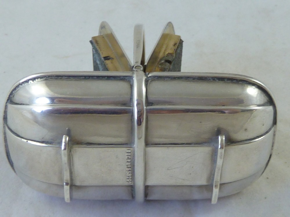 An Edwardian sterling silver double stamp case shaped like a garden trug with an overhead handle and two glazed stamp display compartments. View VI