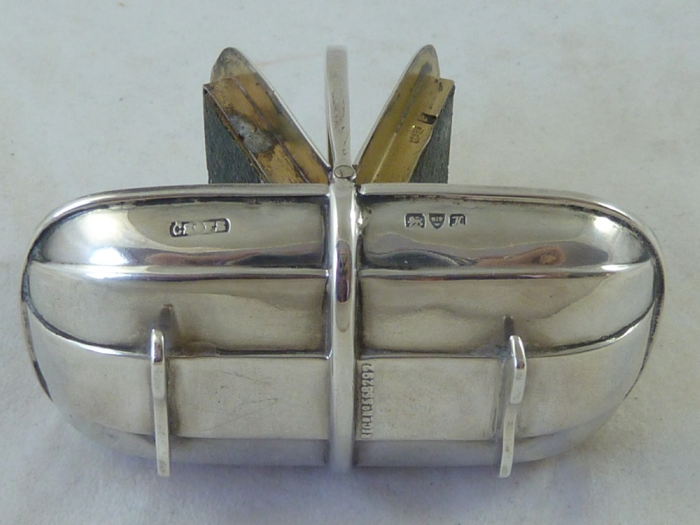 An Edwardian sterling silver double stamp case shaped like a garden trug with an overhead handle and two glazed stamp display compartments. View VII