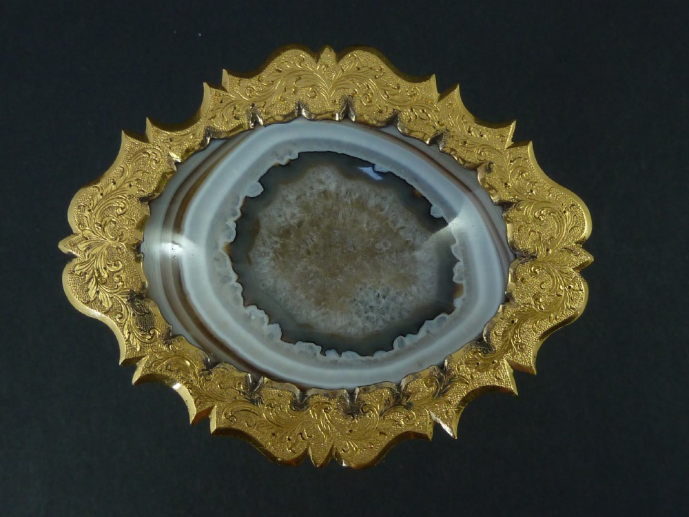 A miniature gilt brass tazza bowl featuring a central polished banded agate stone set within a chased Rococo scrollwork edge and pedestal foot. View III