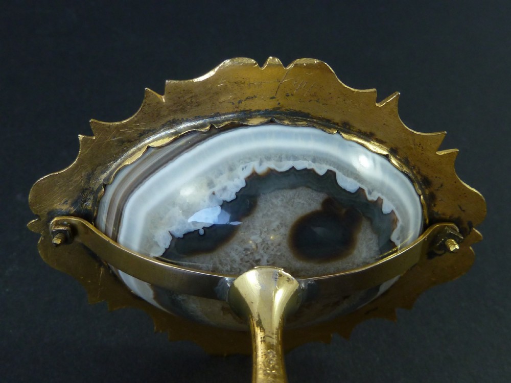 A miniature gilt brass tazza bowl featuring a central polished banded agate stone set within a chased Rococo scrollwork edge and pedestal foot. View VIII