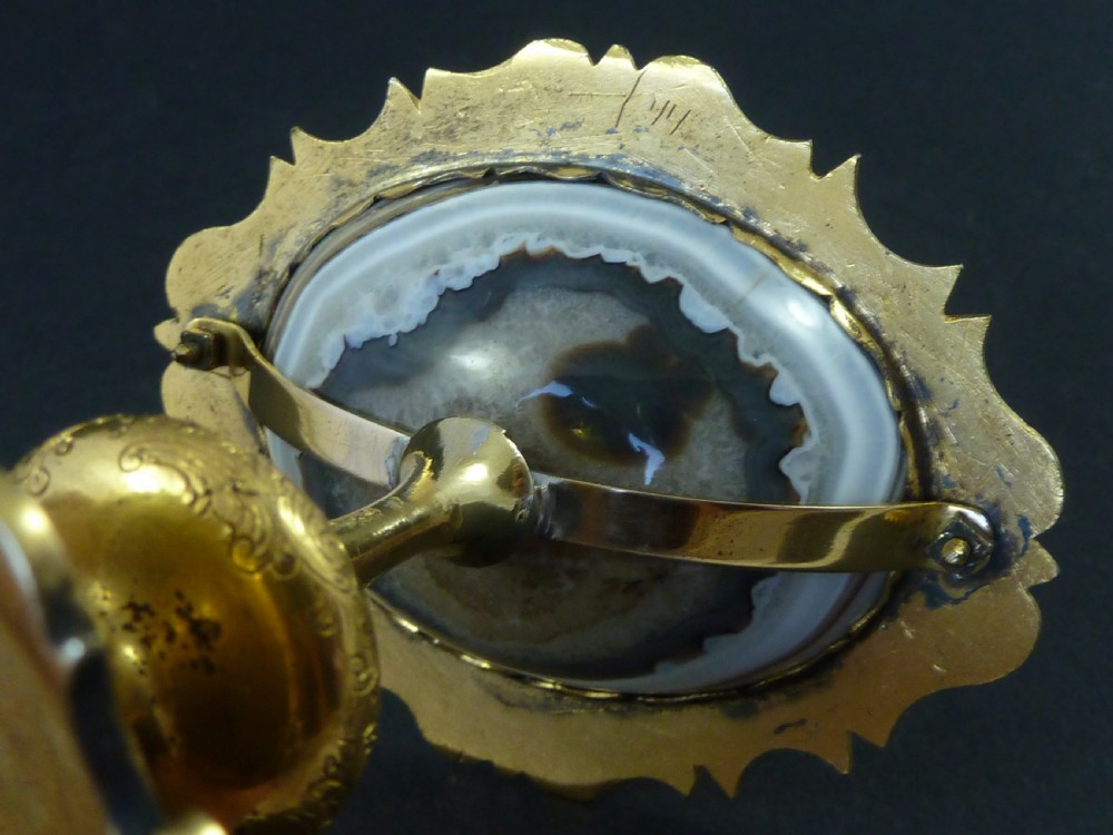 A miniature gilt brass tazza bowl featuring a central polished banded agate stone set within a chased Rococo scrollwork edge and pedestal foot. View IX