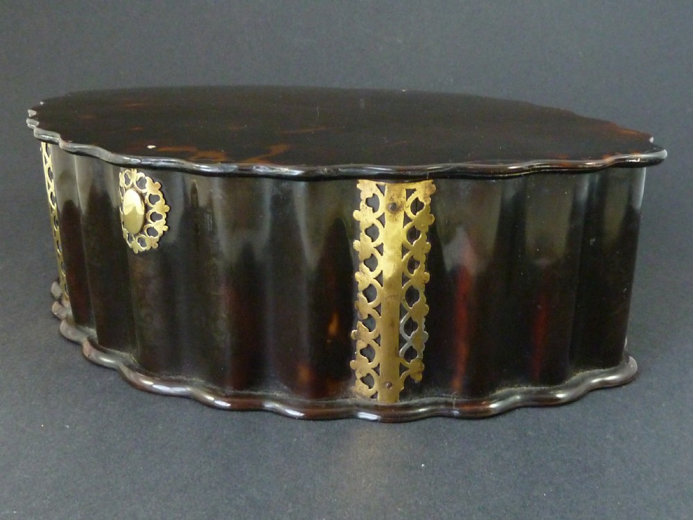 An eighteenth-century lobed Dutch Colonial tortoiseshell casket featuring pierced silver-gilt strapwork mounts and an oval lock plate.