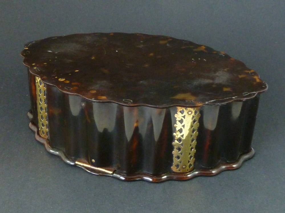 An eighteenth-century lobed Dutch Colonial tortoiseshell casket featuring pierced silver-gilt strapwork mounts and an oval lock plate. View V