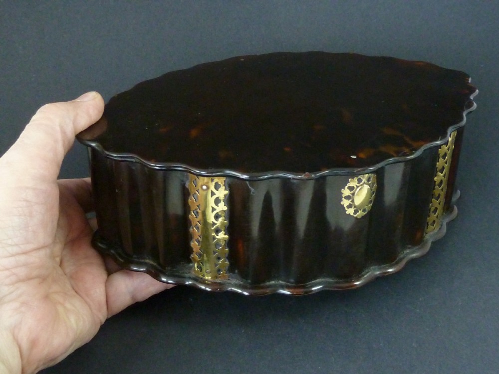 An eighteenth-century lobed Dutch Colonial tortoiseshell casket featuring pierced silver-gilt strapwork mounts and an oval lock plate. View X