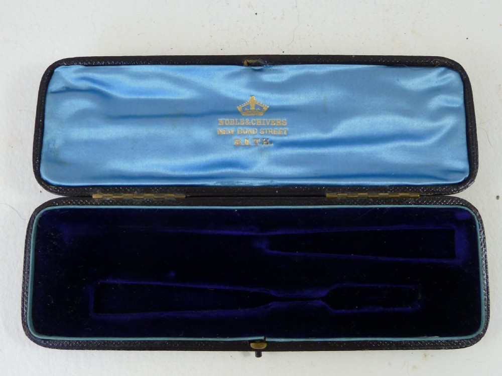 A boxed two-piece Georgian silver fruit knife and fork set with mother-of-pearl handles inside a blue velvet-lined case. View II