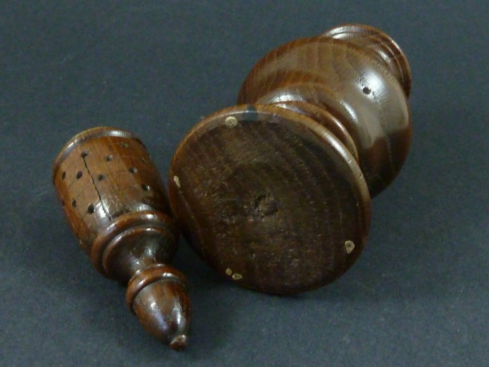 A turned dark wood sugar caster featuring a baluster form, pierced dome top with a finial, and a pedestal base. View V