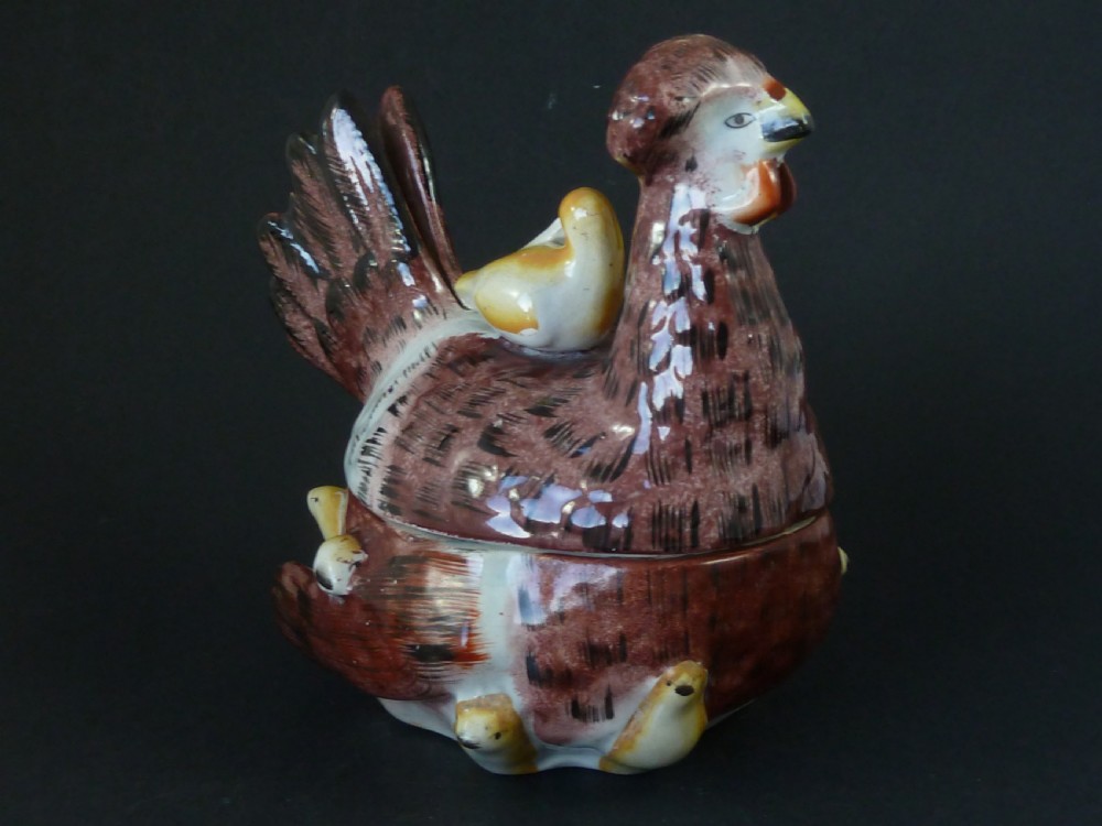 A Victorian glazed earthenware egg tureen shaped like a brown and white hen with small chicks resting along the lid and base. View III