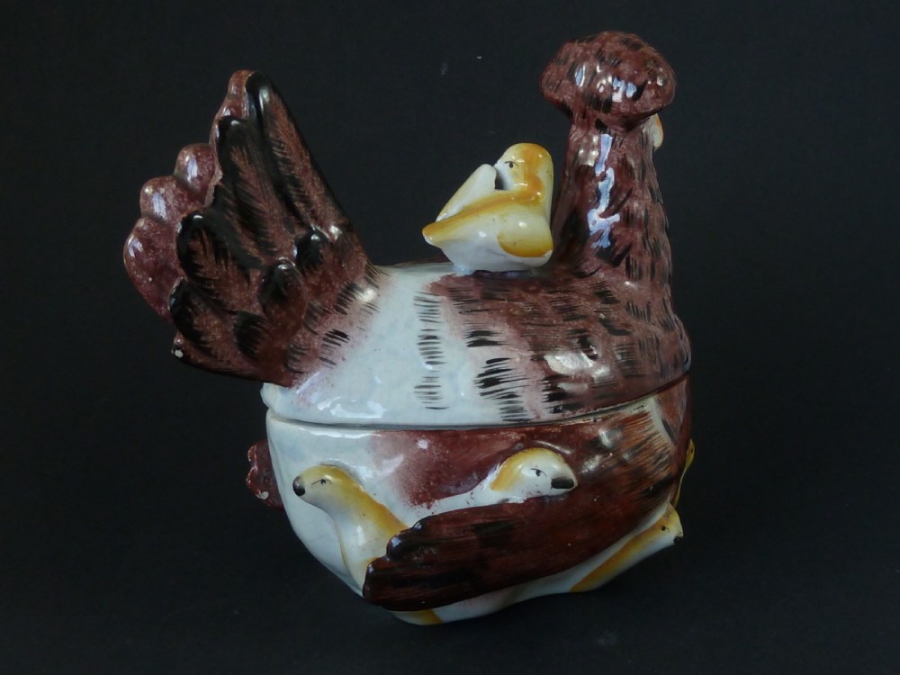 A Victorian glazed earthenware egg tureen shaped like a brown and white hen with small chicks resting along the lid and base. View IV