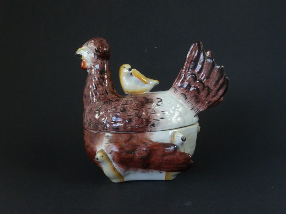 A Victorian glazed earthenware egg tureen shaped like a brown and white hen with small chicks resting along the lid and base. View VI