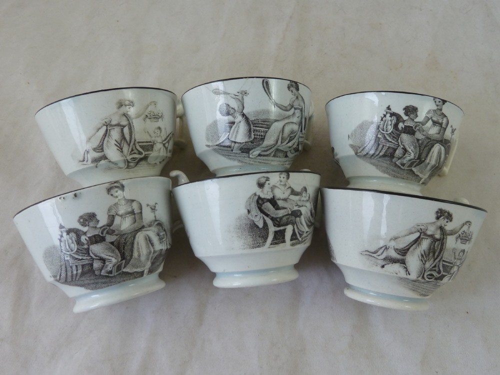 A Georgian era black transfer-printed miniature pearlware tea set featuring a teapot, sugar bowl, milk jug, bowls, cups, and saucers decorated with classical figural scenes. View XII