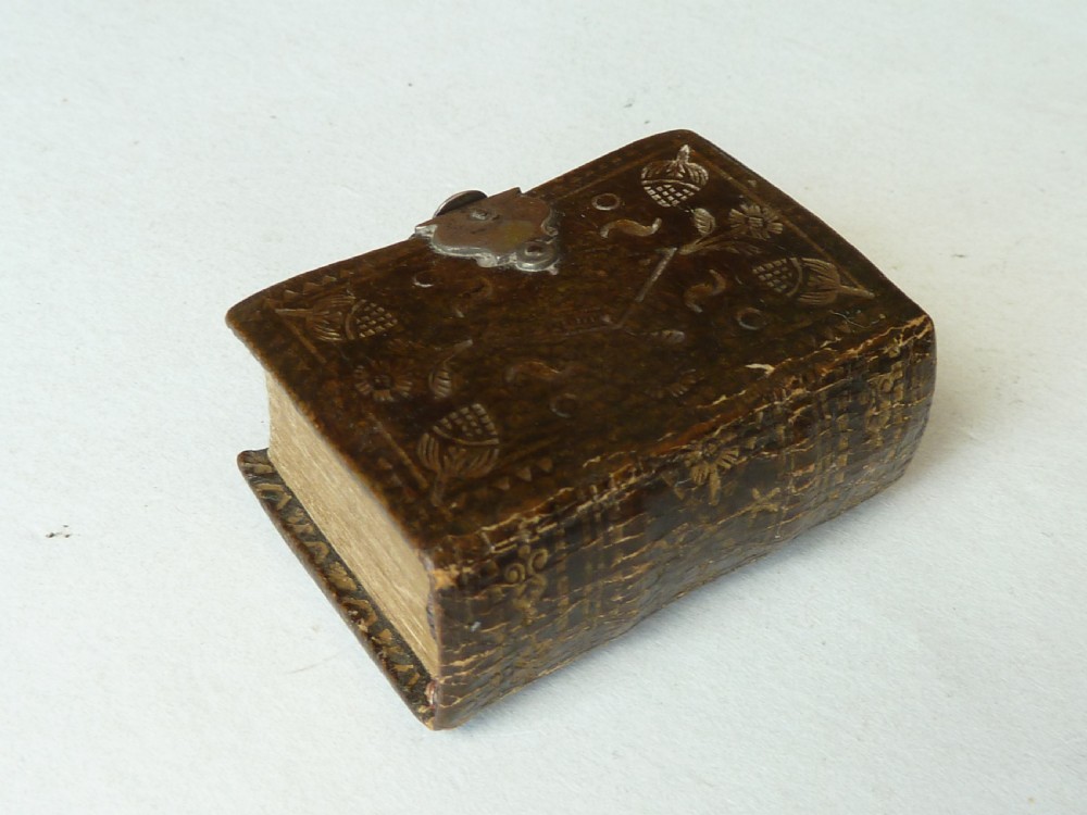 An 18th-century miniature leather-bound thumb bible featuring embossed acorn motifs and a metal clasp closure. View II