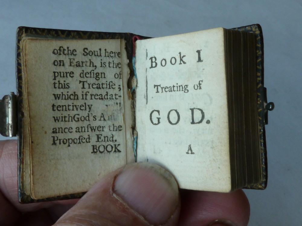An 18th-century miniature leather-bound thumb bible featuring embossed acorn motifs and a metal clasp closure. View III