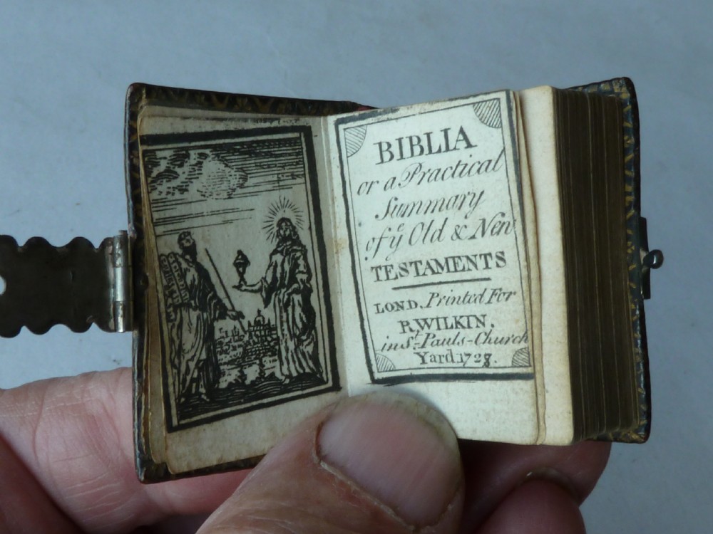 An 18th-century miniature leather-bound thumb bible featuring embossed acorn motifs and a metal clasp closure. View IV