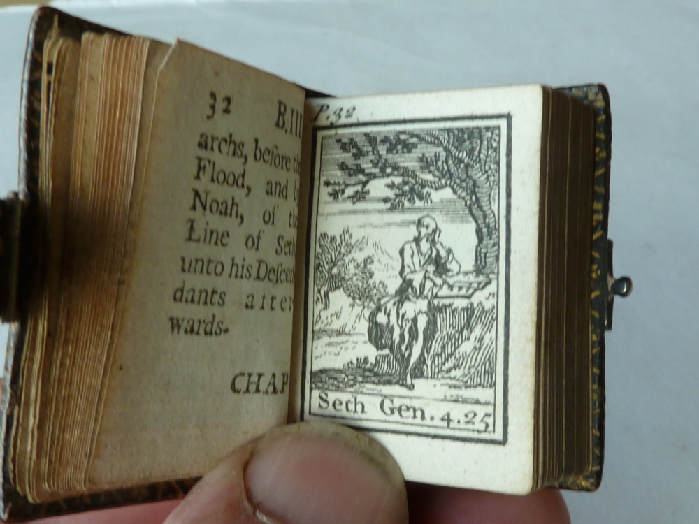 An 18th-century miniature leather-bound thumb bible featuring embossed acorn motifs and a metal clasp closure. View VII